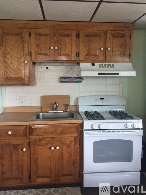 A kitchen with wooden cabinets and a white stove.