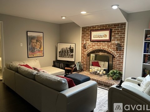 A living room with a grey couch and a fireplace.