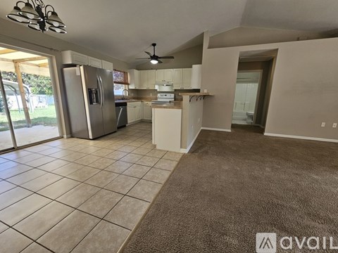 A kitchen with a refrigerator, sink, and stove is available for rent.