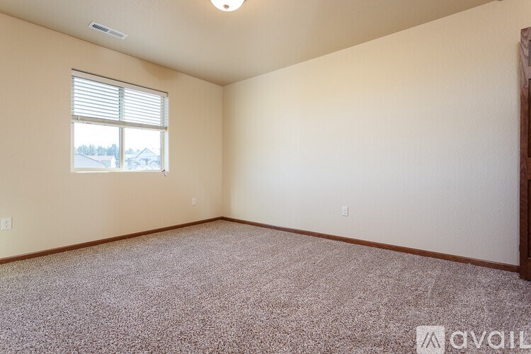 A room with a window and carpeted floor.