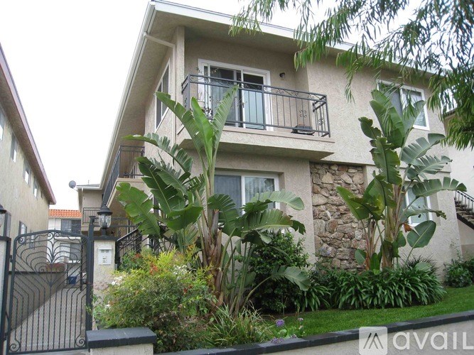 A house with a balcony and a gate in front of it.
