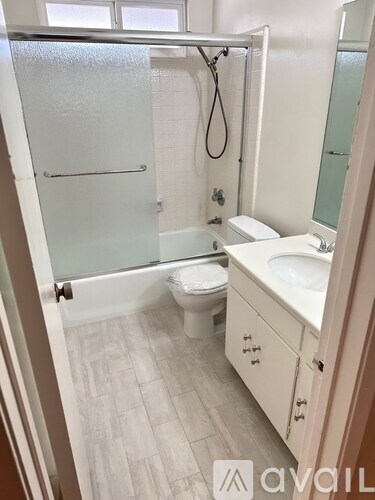 A bathroom with a toilet, sink, and shower.