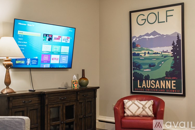 A living room with a TV displaying a Netflix interface and a poster of a golf course.