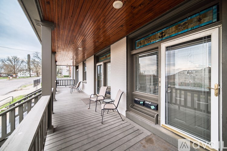 A wooden porch with a glass door and a window.