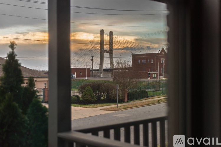 A view from a balcony looking out at a street with houses and a bridge in the distance.