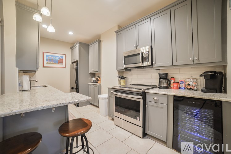A kitchen with a white counter top and grey cabinets.