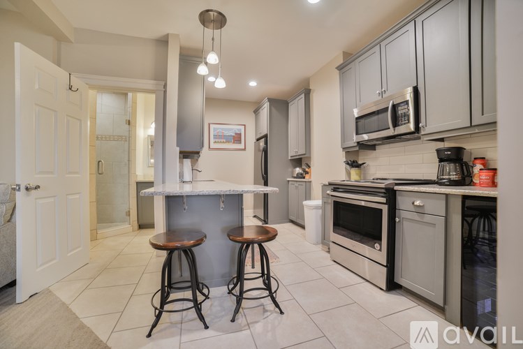 A modern kitchen with a bar area and a refrigerator on the wall.