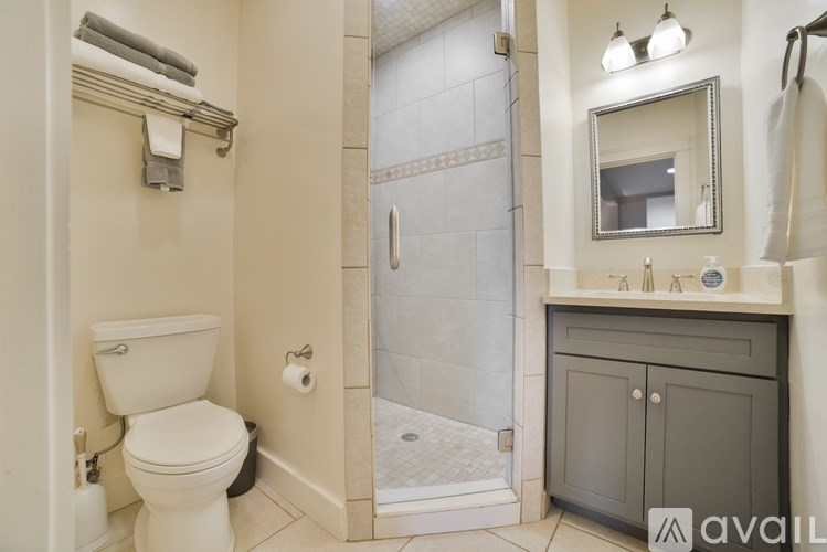 A bathroom with a toilet, sink, and shower.