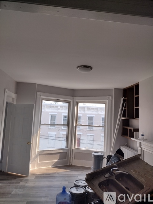 A room with a window and a door is available for rent.