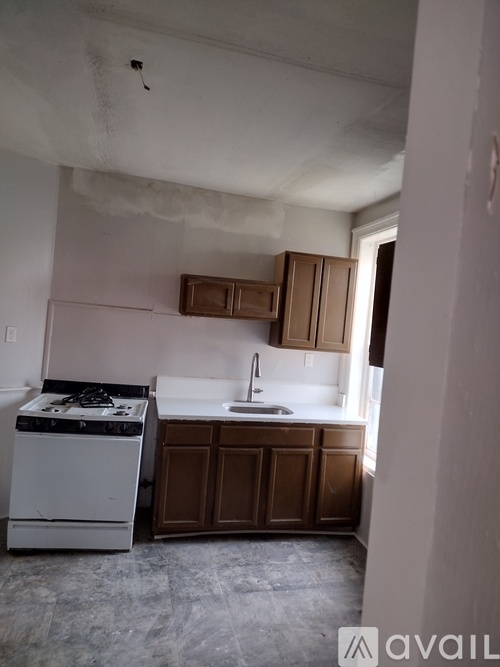 A kitchen with a white stove and brown cabinets.