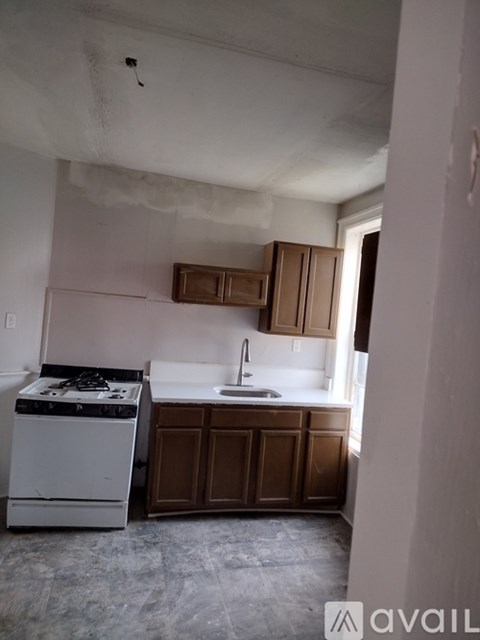 A kitchen with a white stove and brown cabinets.
