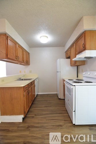 A kitchen with white appliances and wooden cabinets.