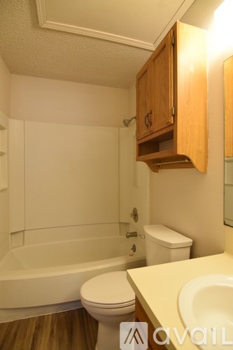 A white toilet sits in a bathroom next to a bathtub.