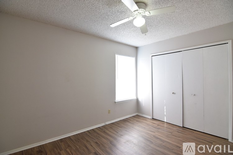 A room with a ceiling fan and a window.