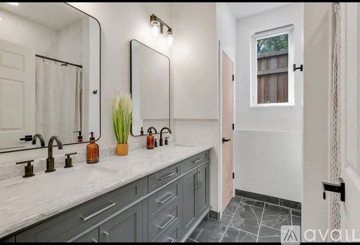 A bathroom with a marble countertop and a large mirror.