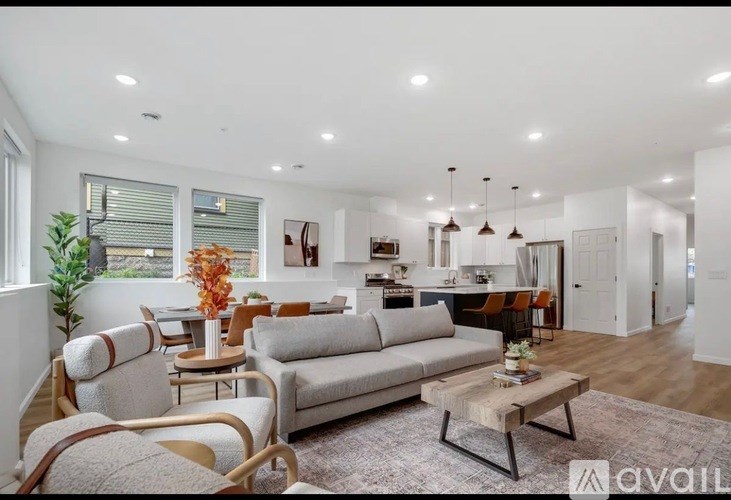 A living room with a grey sofa, wooden chairs, and a coffee table.
