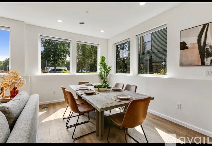 A dining room with a table set for four and a couch.