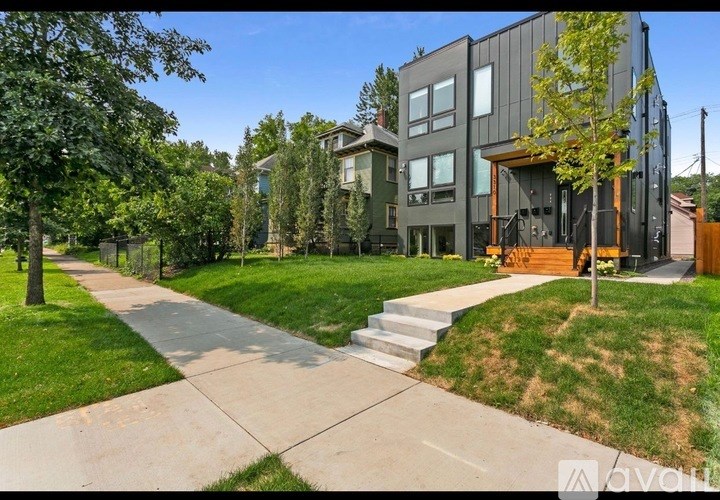 A modern house with a grey exterior and a large front yard.