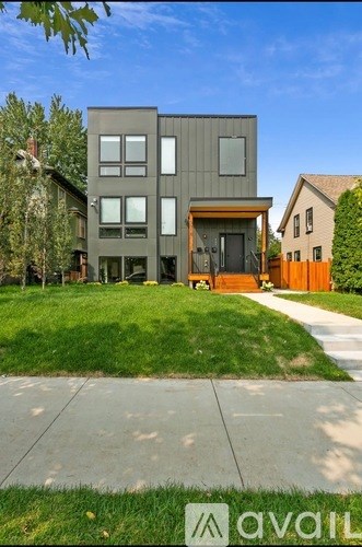 A modern house with a grey exterior and a brown door.