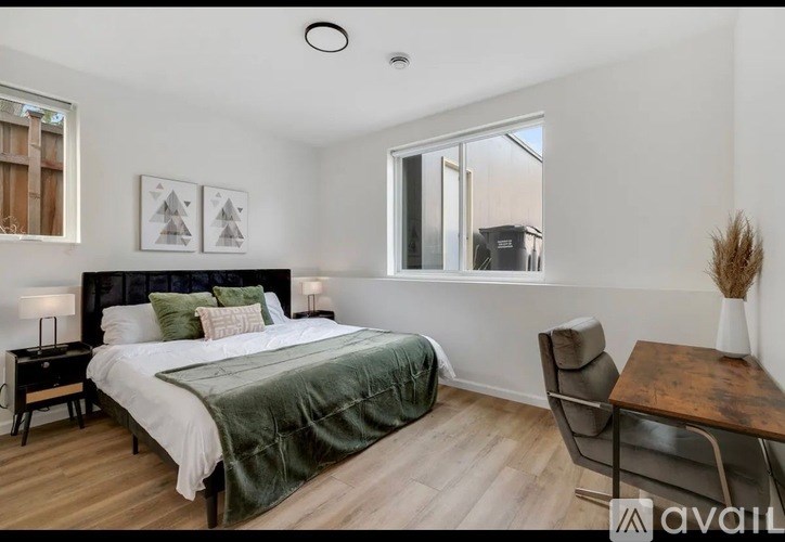 A bedroom with a bed, chair, and a table.