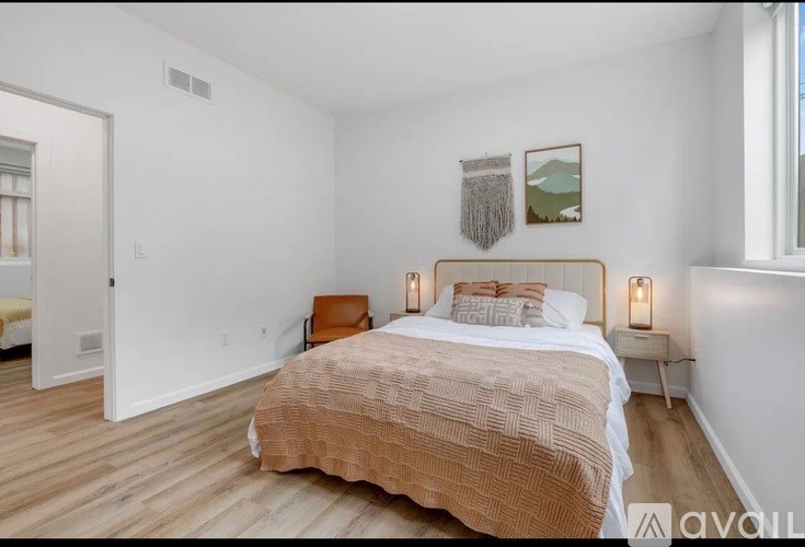 A bedroom with a bed, a chair, and a window.