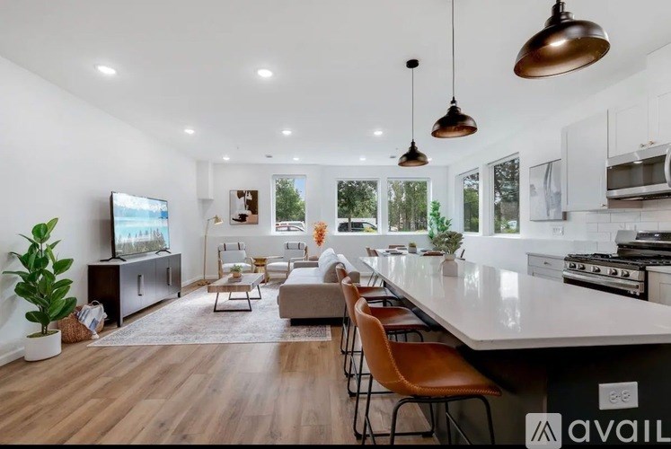 A modern kitchen with a long island and chairs.