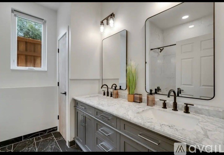 A bathroom with a marble countertop and a large mirror.