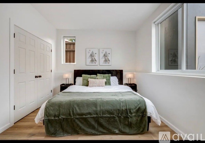 A bedroom with a bed covered in a green blanket.
