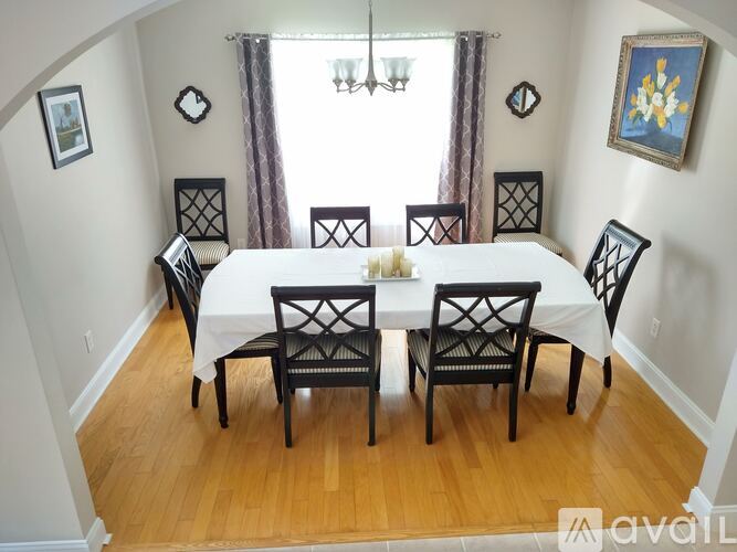 A dining room with a white table and chairs.
