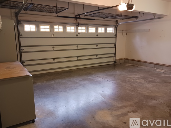 A spacious garage with a white wall and a brown floor.