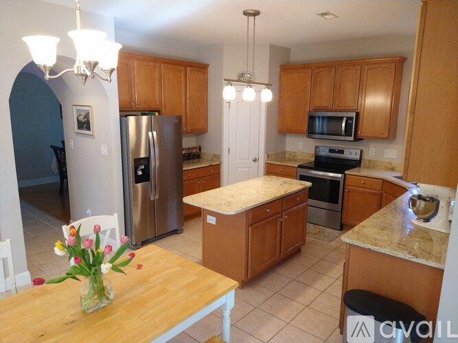 A kitchen with wooden cabinets and a granite countertop.