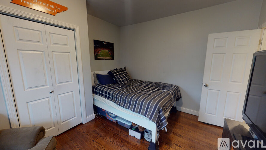 A bedroom with a bed, a couch, and a television.