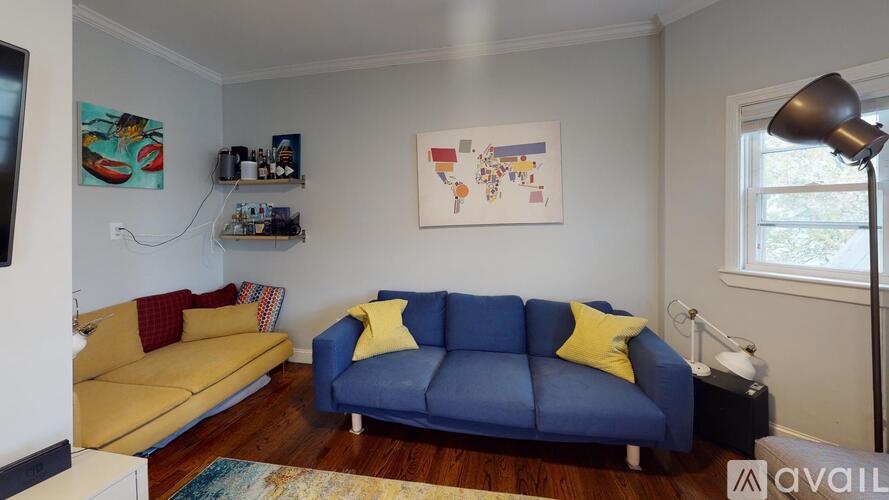 A living room with a blue couch and a yellow couch.