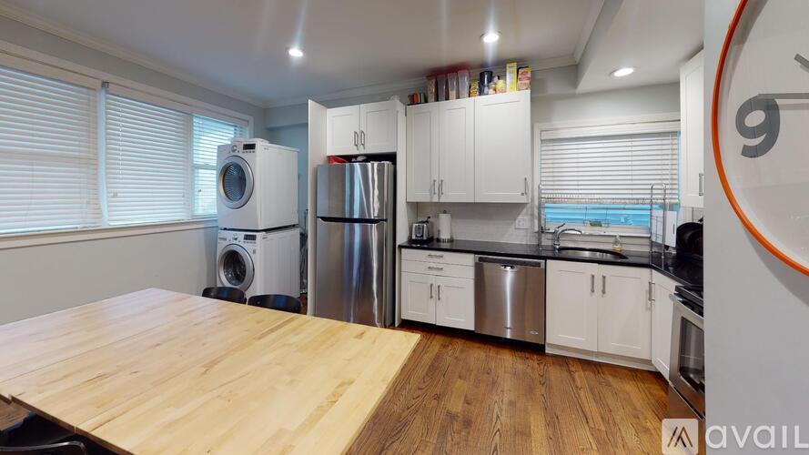 A kitchen with a wooden table and stainless steel appliances.