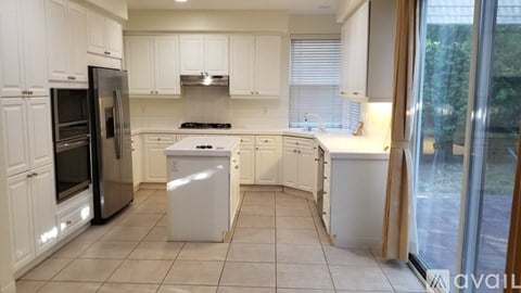 A kitchen with white cabinets and appliances.