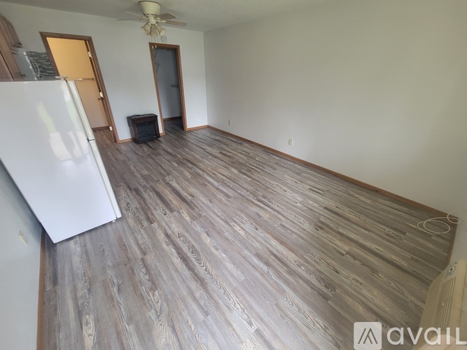 A room with a carpeted floor and a ceiling fan.