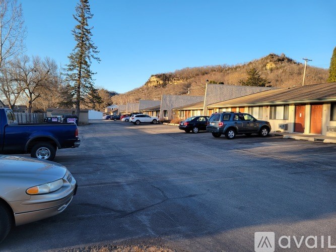 A parking lot with cars and a mountain in the background.
