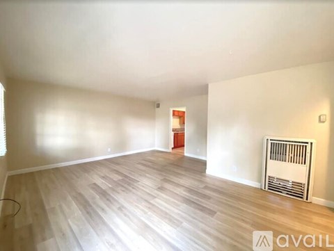 A room with wooden flooring and a radiator on the wall.