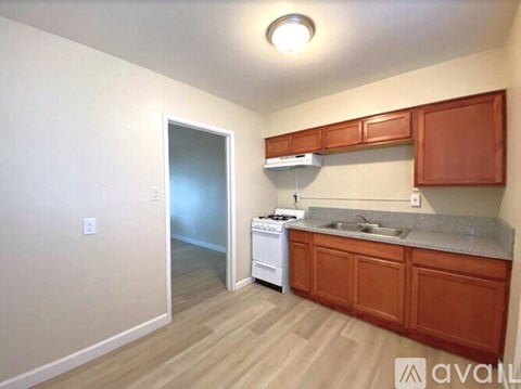 A kitchen with wooden cabinets and a white dishwasher.
