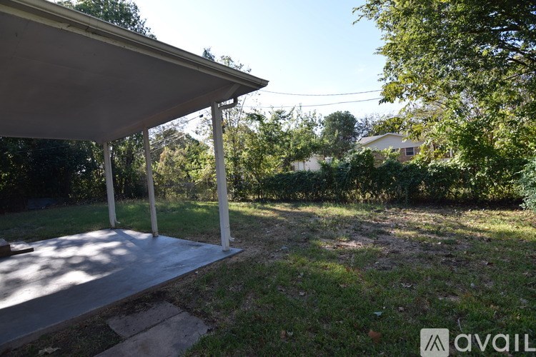 A house with a brown roof and a white door is surrounded by trees.