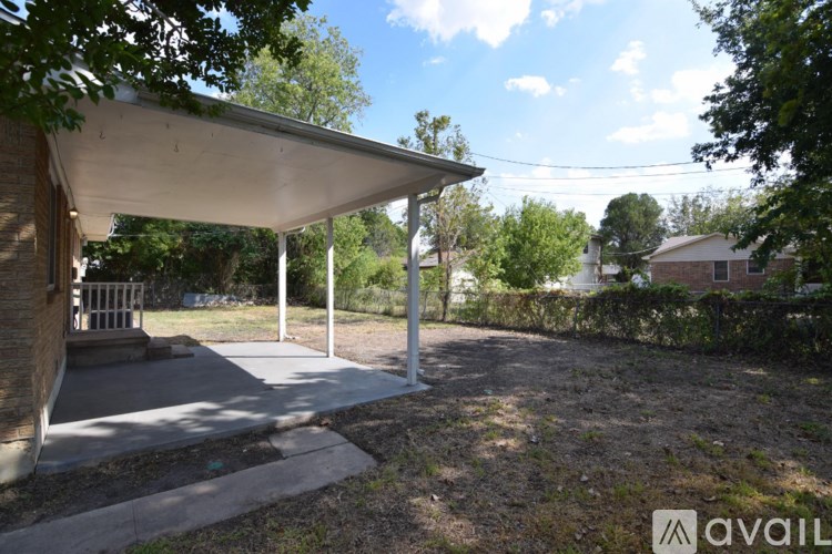 A covered patio area with a white roof and pillars.