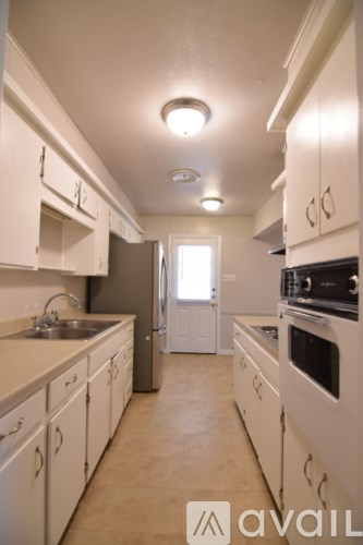 A kitchen with white cabinets and a refrigerator.