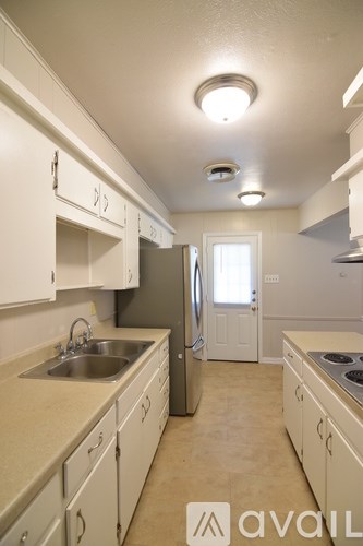 A kitchen with white cabinets and a stainless steel refrigerator.
