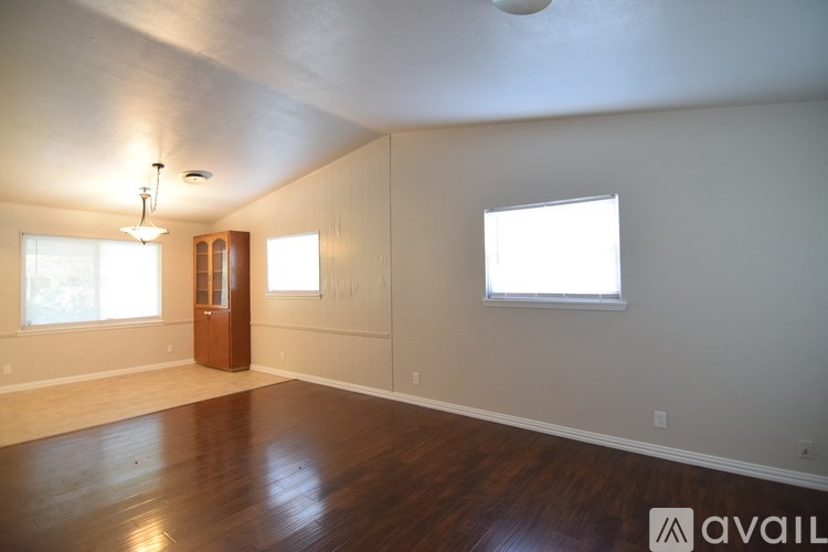 A room with wooden floors and a chandelier hanging from the ceiling.