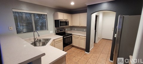A kitchen with a sink, stove, and refrigerator.