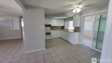A kitchen with white cabinets and a tiled floor.