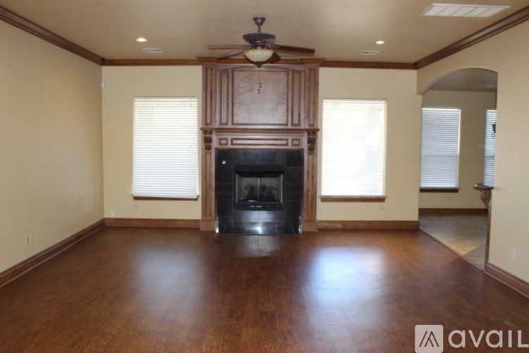 A living room with a fireplace and wood flooring.