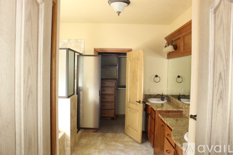 A bathroom with a sink, mirror, and a refrigerator.