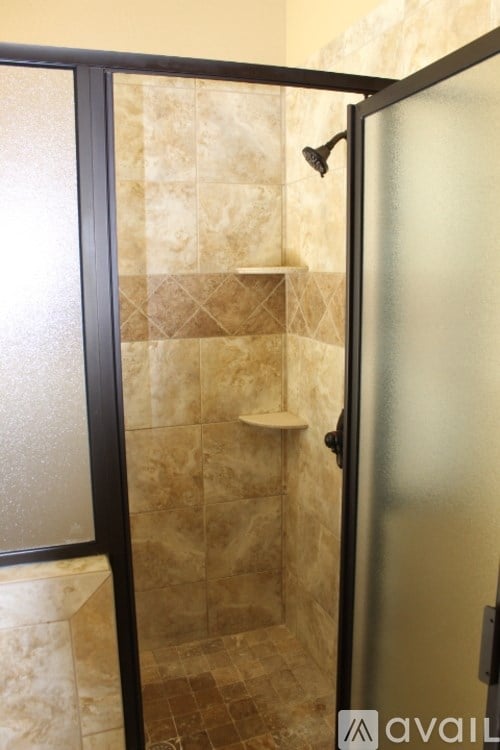 A bathroom with a glass door shower enclosure.