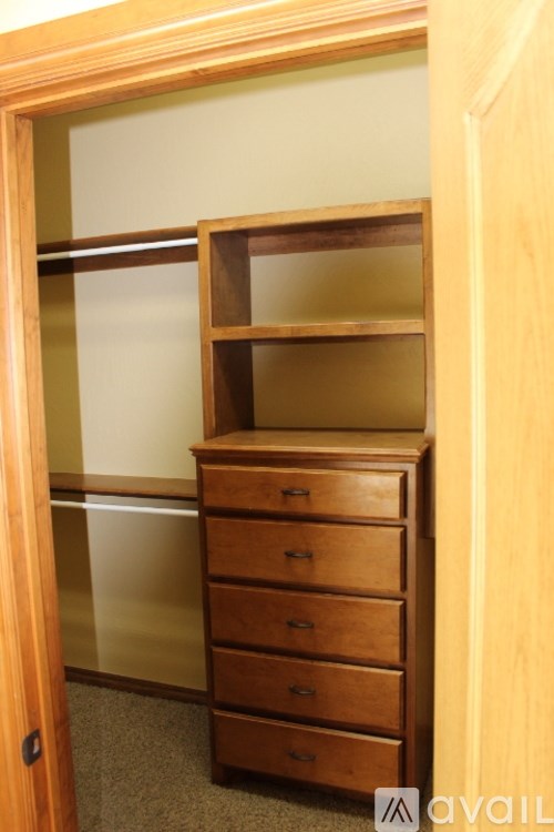 A wooden dresser with a mirrored door stands in a room.
